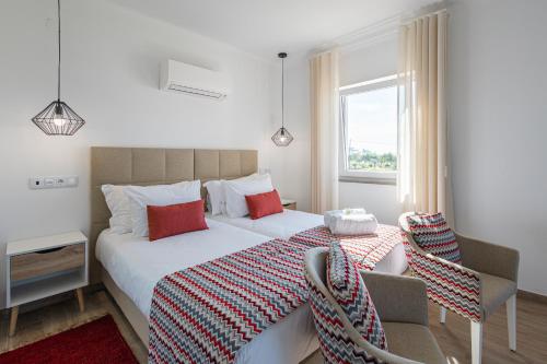 a bedroom with two beds and a window at Monte do Cerro in Porto Covo