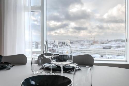 twee lege wijnglazen op een tafel voor een raam bij Sif Apartments by Heimaleiga in Reykjavík