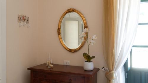 a mirror on a wall next to a dresser and a window at Villa Il Casale Onifai- piano terra in Onifai