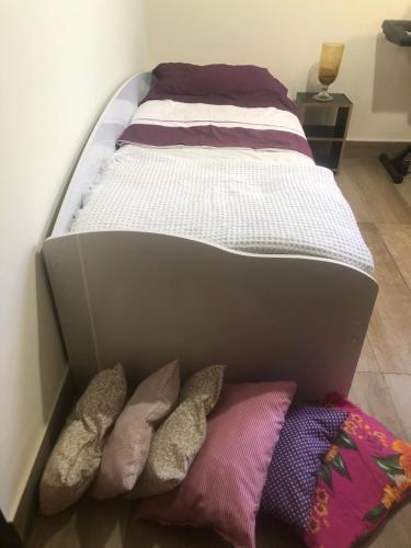 a bed in a box with some pillows at Quarto privativo Sanilda in Vitória