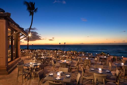 a restaurant on the beach with tables and chairs at Hilton Grand Vacations Club Ocean Tower Waikoloa Village in Waikoloa