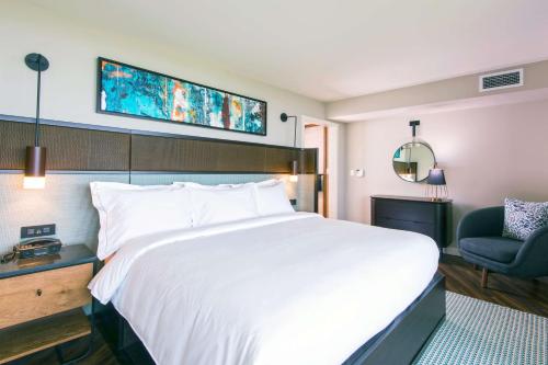 a bedroom with a large white bed and a chair at Hilton Grand Vacations Club Ocean Tower Waikoloa Village in Waikoloa