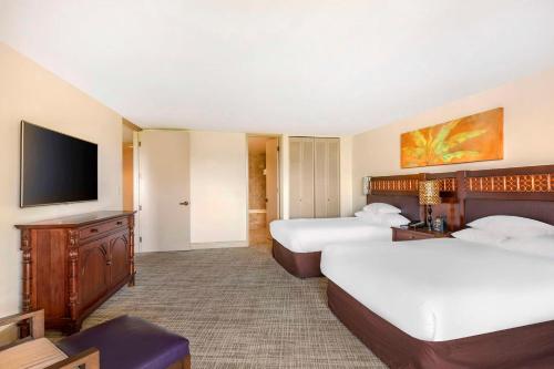 a hotel room with two beds and a flat screen tv at Hilton Grand Vacations Club Ocean Tower Waikoloa Village in Waikoloa