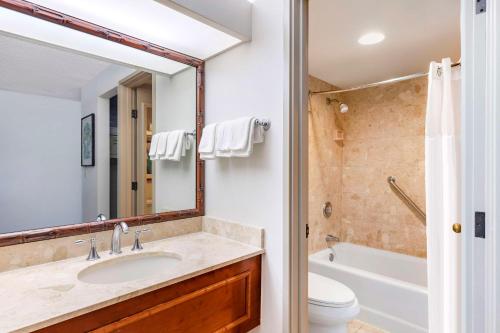 a bathroom with a sink and a tub and a toilet at Hilton Grand Vacations Club Ocean Tower Waikoloa Village in Waikoloa