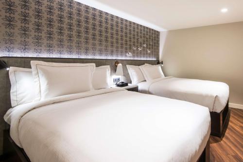 two beds in a hotel room with white pillows at Hilton Grand Vacations Club Ocean Tower Waikoloa Village in Waikoloa