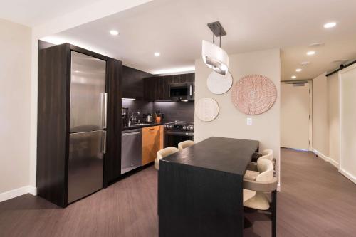a kitchen with a black table and a refrigerator at Hilton Grand Vacations Club Ocean Tower Waikoloa Village in Waikoloa
