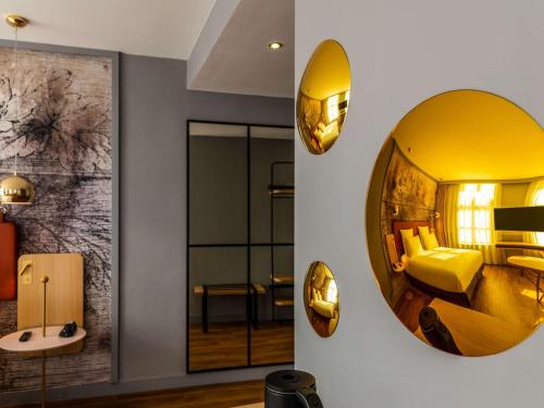 une chambre d'hôtel avec un grand miroir sur le mur dans l'établissement Mercure Saint Omer Centre Gare, à Saint-Omer
