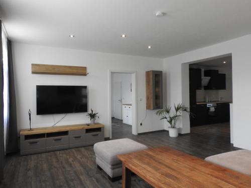 a living room with a flat screen tv on a wall at Ferienwohnungen am Hauptplatz in Pirna