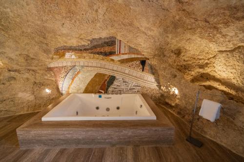 a bathroom with a bath tub in a stone wall at L-Eremita Boutique Hotel in Qala