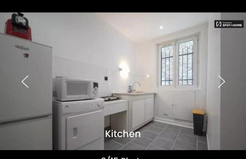 une cuisine avec un micro-ondes et une cuisinière four supérieur dans l'établissement Studio près de la Porte Maillot, à Paris