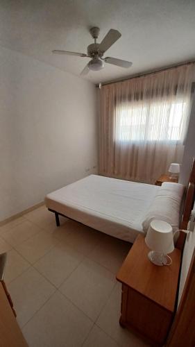 sypialnia z łóżkiem i wentylatorem sufitowym w obiekcie Marazul Orangecosta w mieście Peñíscola