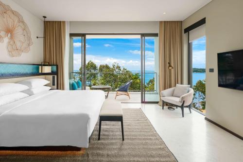 Hyatt Regency Koh Samui- SHA Extra Plus في شاطئ تشاوينغ: غرفة نوم مع سرير وإطلالة على المحيط