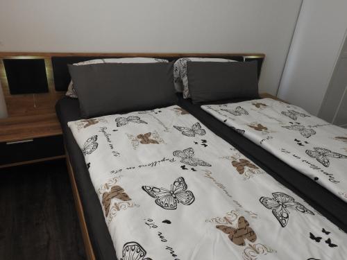 a bed with a bedspread with butterflies on it at Ferienwohnungen am Hauptplatz in Pirna