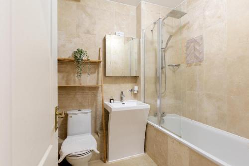 y baño con aseo, lavabo y ducha. en The Tower Bridge Apartment en Londres