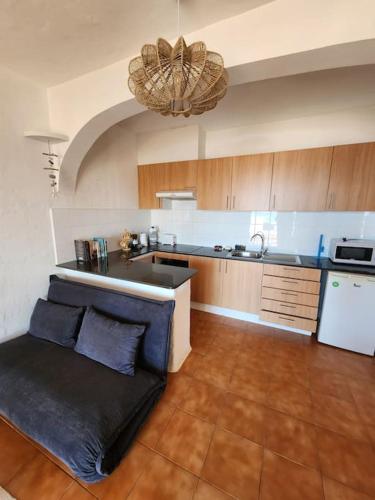 a kitchen with a couch in the middle of a room at Charmant appartement vue mer in Fornells