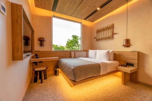 a bedroom with a large bed and a window at Motto By Hilton Tulum in Tulum
