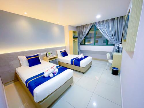 クアラルンプールにあるStarQ Hotel Kuala Lumpurのホテルルーム ベッド2台(人形付)