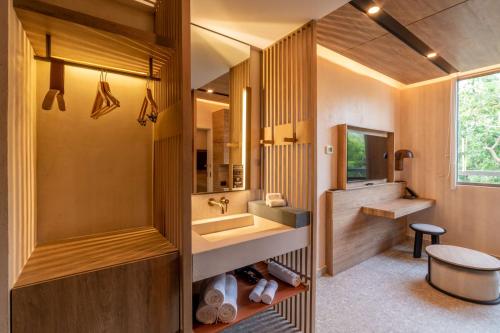 a bathroom with a sink and a mirror at Motto By Hilton Tulum in Tulum