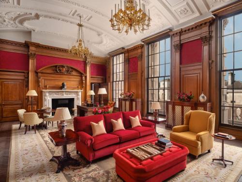 a living room with a red couch and a fireplace at Raffles London at The OWO in London