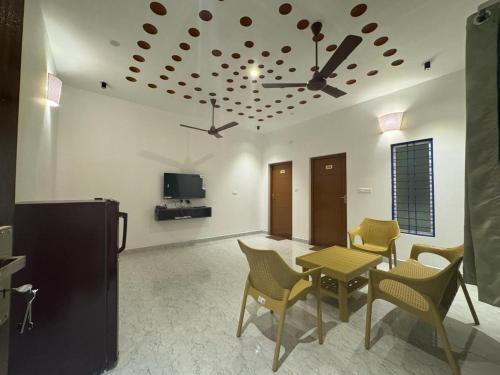 a living room with a table and chairs and a tv at La Tamara Suite - TIE Hotels & Resorts in Puducherry