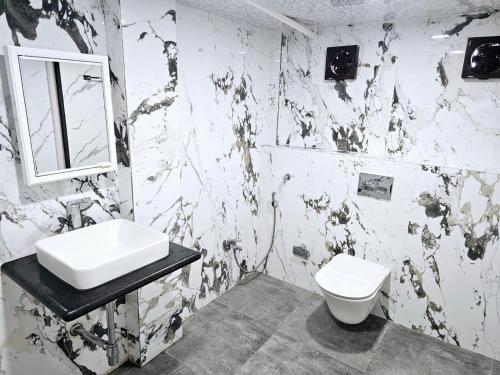 a black and white bathroom with a sink and a toilet at Jjs PARK INN in Chennai