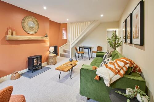 a living room with a green couch and a fireplace at Host & Stay - Cinnamon Cottage in Barnard Castle