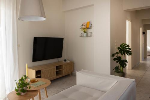 a living room with a television and a white couch at Ursa Minor in Mousata