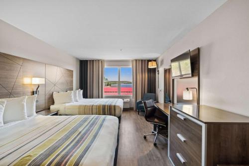 a hotel room with two beds and a desk at Country Inn & Suites by Radisson, Myrtle Beach, SC in Myrtle Beach