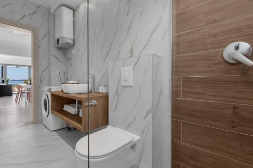 a bathroom with a toilet and a glass shower at Beachfront Apartment Beach Makarska Residence Srzić in Makarska
