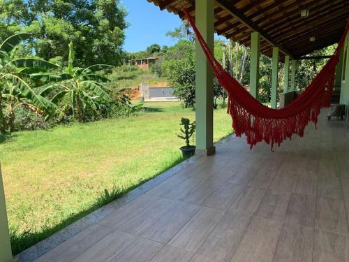een hangmat hangend aan een veranda met een tuin bij Sitio Canto Caipira in Vila Velha