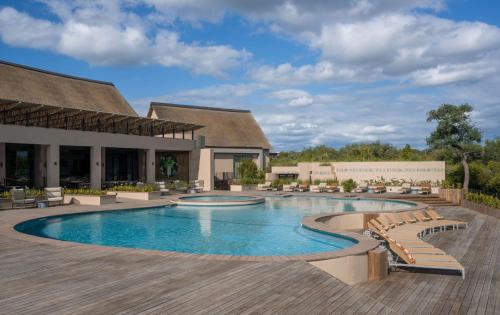 a pool at a resort with lounge chairs at Radisson Safari Hotel Hoedspruit in Hoedspruit