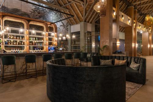 un bar con sedie nere e bancone da bar di Radisson Safari Hotel Hoedspruit a Hoedspruit
