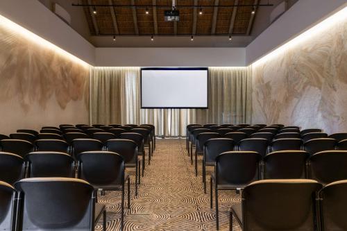 a conference room with chairs and a projection screen at Radisson Safari Hotel Hoedspruit in Hoedspruit