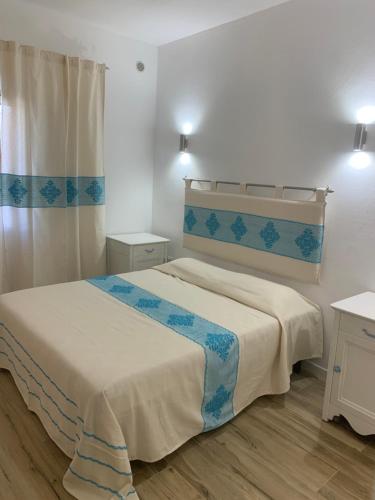 a small bedroom with a bed and a window at Budoni Beach Apartments in Budoni