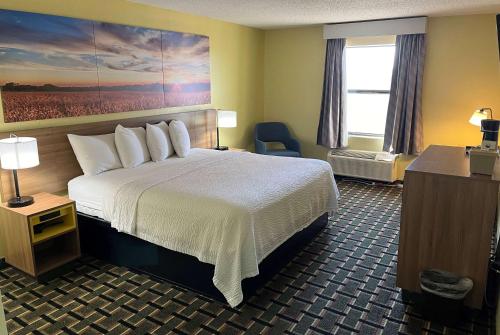 um quarto de hotel com uma cama grande e uma janela em Days Inn by Wyndham Park City Kansas em Park City