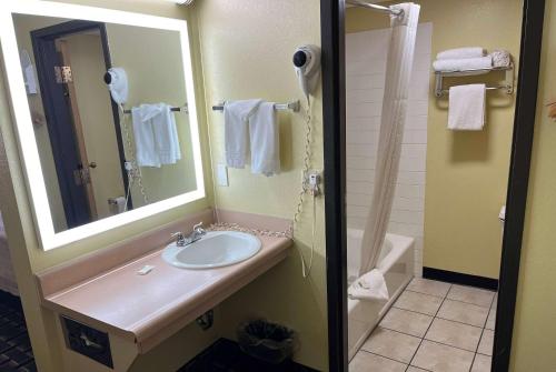 uma casa de banho com um lavatório e um espelho em Days Inn by Wyndham Park City Kansas em Park City