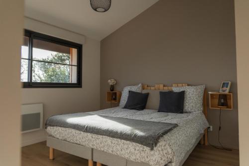 une chambre avec un lit et une fenêtre dans l'établissement Flou de Pin, à Lège-Cap-Ferret