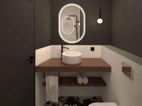 La salle de bains est pourvue d'un lavabo et d'un miroir. dans l'établissement Hotel et Spa Fort St Laurent Lyon - Handwritten Collection, à Lyon