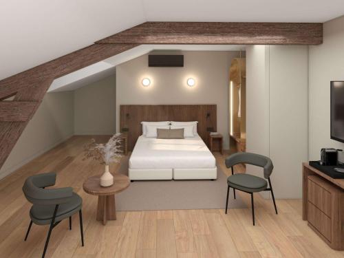 um quarto com uma cama, 2 cadeiras e uma mesa em Hotel et Spa Fort St Laurent Lyon - Handwritten Collection em Lyon