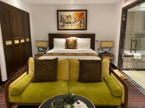 a bedroom with a bed and a green couch at JB Serviced Apartment in Hanoi