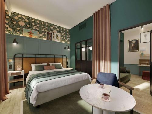 ein Schlafzimmer mit einem Bett und einem Tisch in einem Zimmer in der Unterkunft Square Lodge Hotel La Roche sur Yon - Handwritten Collection in La Roche-sur-Yon