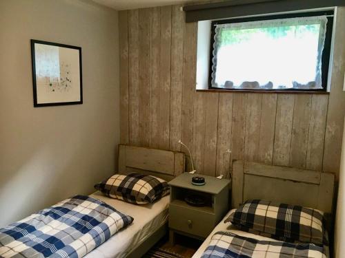 2 Einzelbetten in einem Zimmer mit Fenster in der Unterkunft Hisa Smast in Kobarid