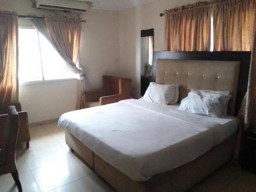 um quarto com uma cama grande e uma janela em St Theresers apartment Lodge 2 em Lekki