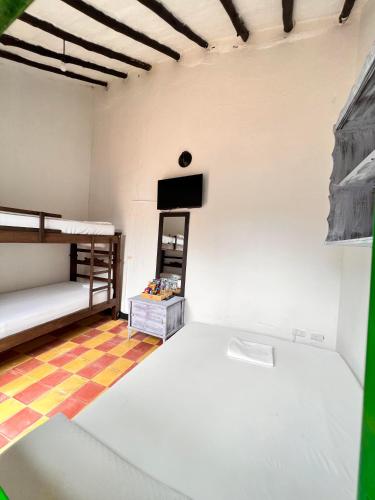 a room with two bunk beds and a flat screen tv at Green Door San Gil in San Gil