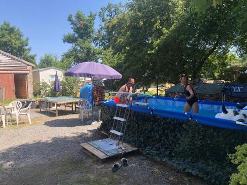 two women in bathing suits standing next to a water slide at Maison Belle Vue in Chiddes