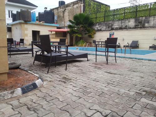 a patio with tables and chairs next to a pool at St Theresers apartment Lodge 2 in Lekki