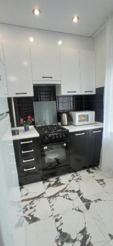 une cuisine avec des appareils noirs et des armoires blanches dans l'établissement ЖД Вокзал и Авто 1 кв Евро, à Dnipro