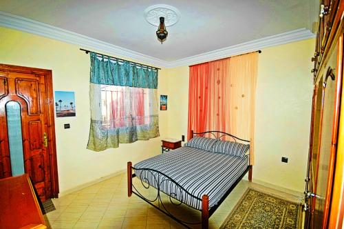 - une chambre avec un lit et une fenêtre dans l'établissement Appartement Vintage à EL JADIDA rte Sidi Bouzid, à El Jadida