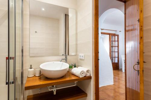 a bathroom with a white bowl sink on a wooden counter at Vistafaro in Es Mercadal