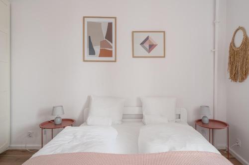 - une chambre avec un lit blanc et 2 tables de chevet dans l'établissement RentPlanet - Apartament Cybulskiego, à Wrocław